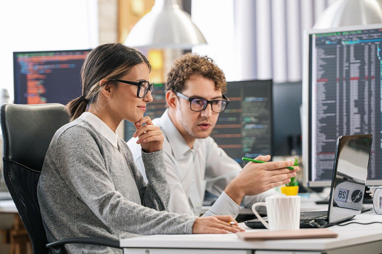 Two individuals collaborating at a computer