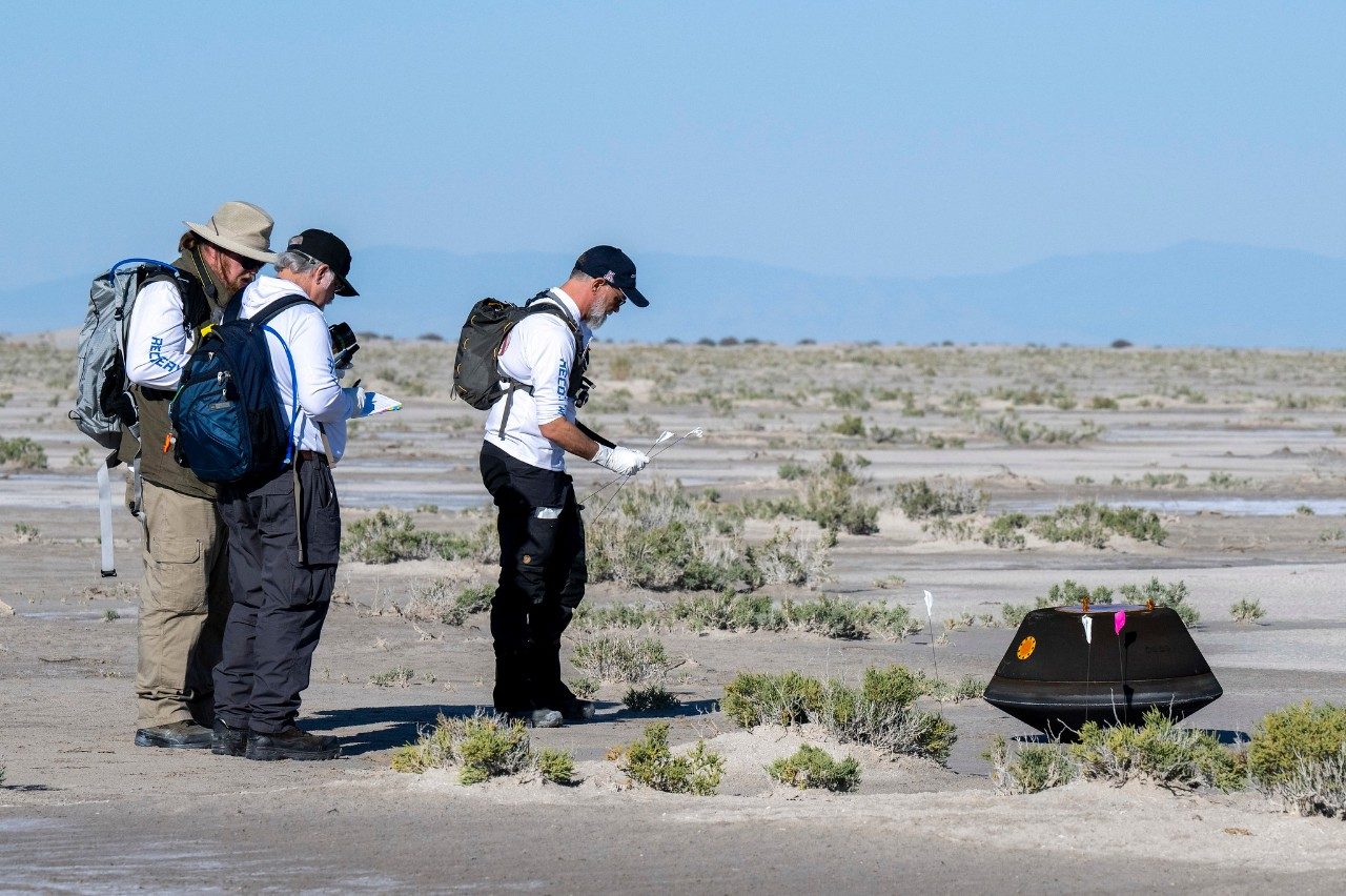 The OSIRIS-REx recovery team approaches the sample return capsule